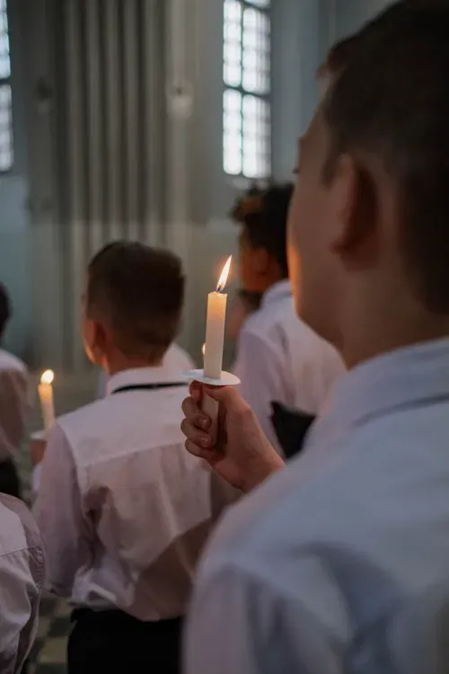 Niños sosteniendo velas encendidas durante una ceremonia